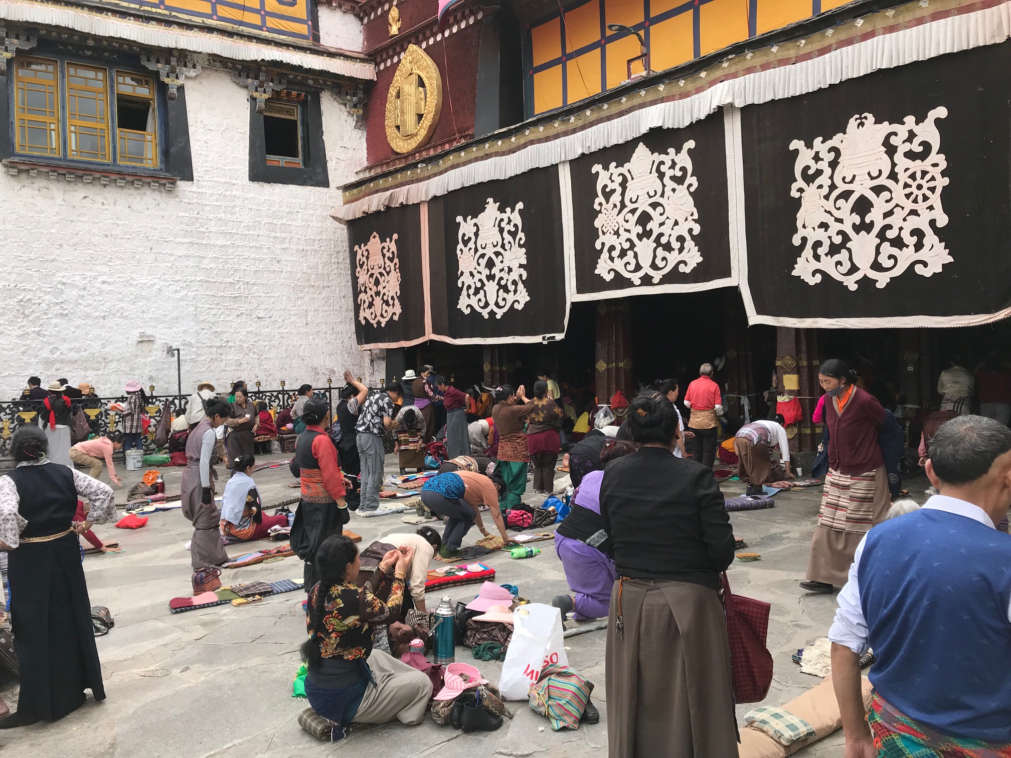 Tibetan pilgrims performing prostrations at the Jokhang Temple, Lhasa, Tibet
